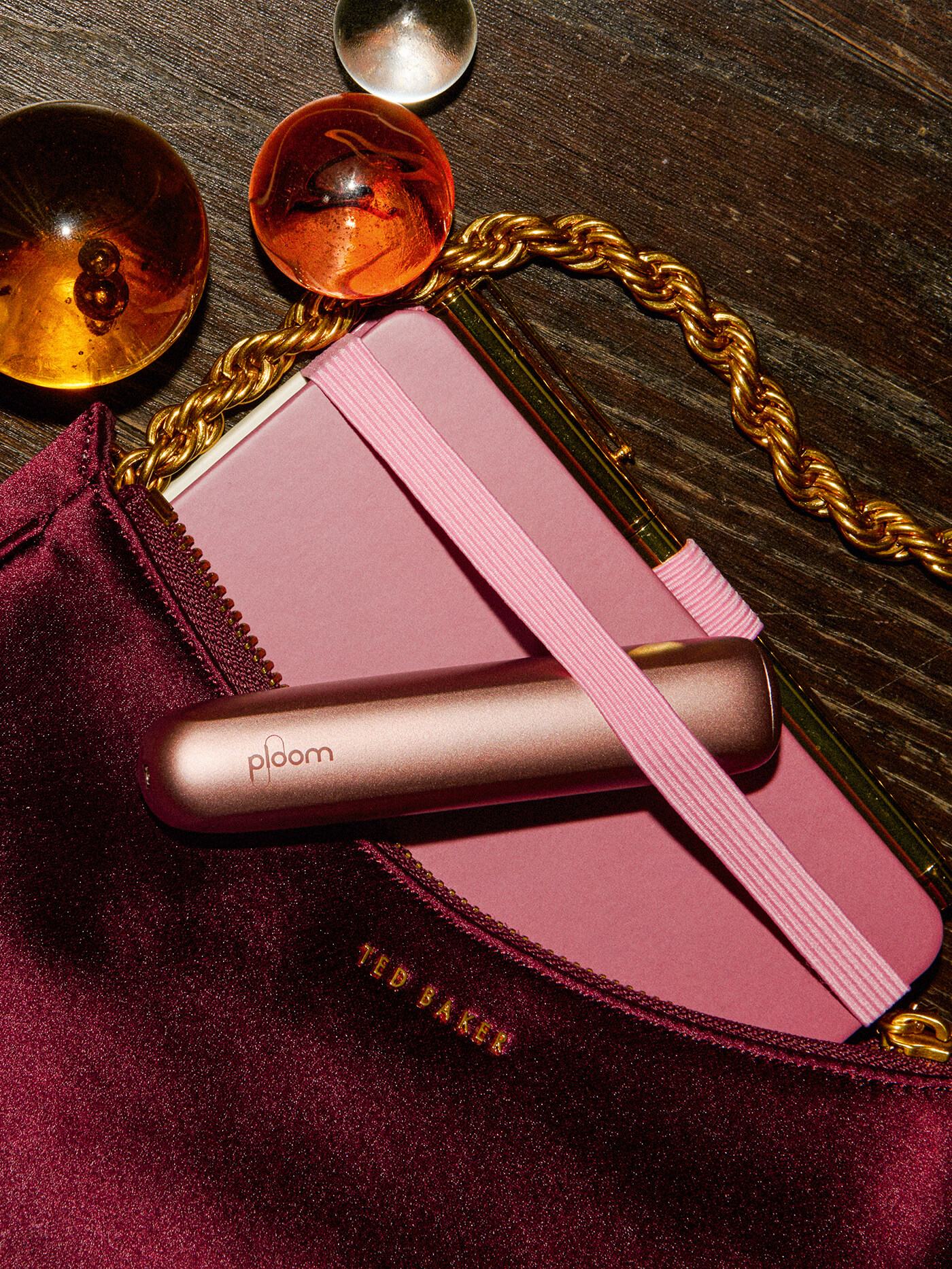 Συσκευή Ploom Aura πάνω σε βελούδινη τσάντα με κοσμήματα